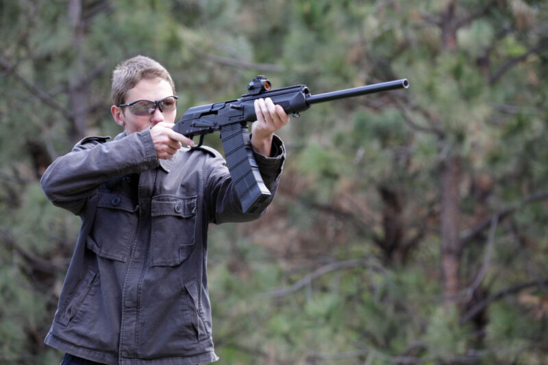 UltiMAK M11 Optic Mount on Saiga-12 Shotgun, man with glasses aiming